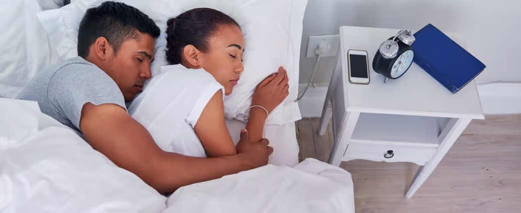 Sleeping couple in bed trying to get more REM sleep