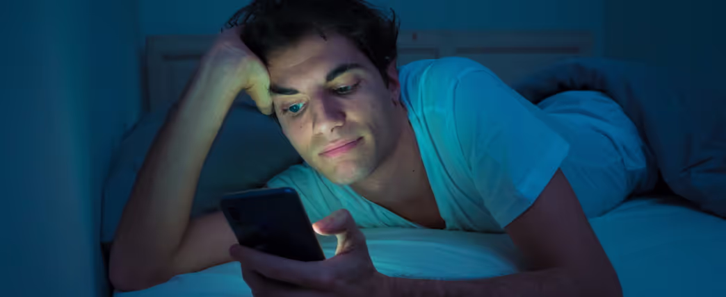 Man doesn't want to sleep and instead is on his phone