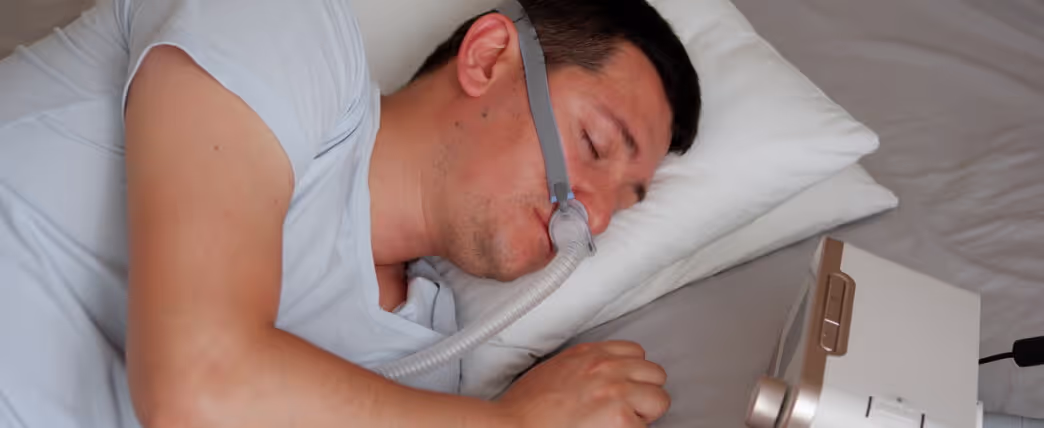 Testosterone and sleep apnea: Man sleeping with CPAP machine.