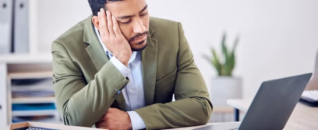 Hombre dormido en su escritorio en la oficina con sueño después de dormir solo 6 horas