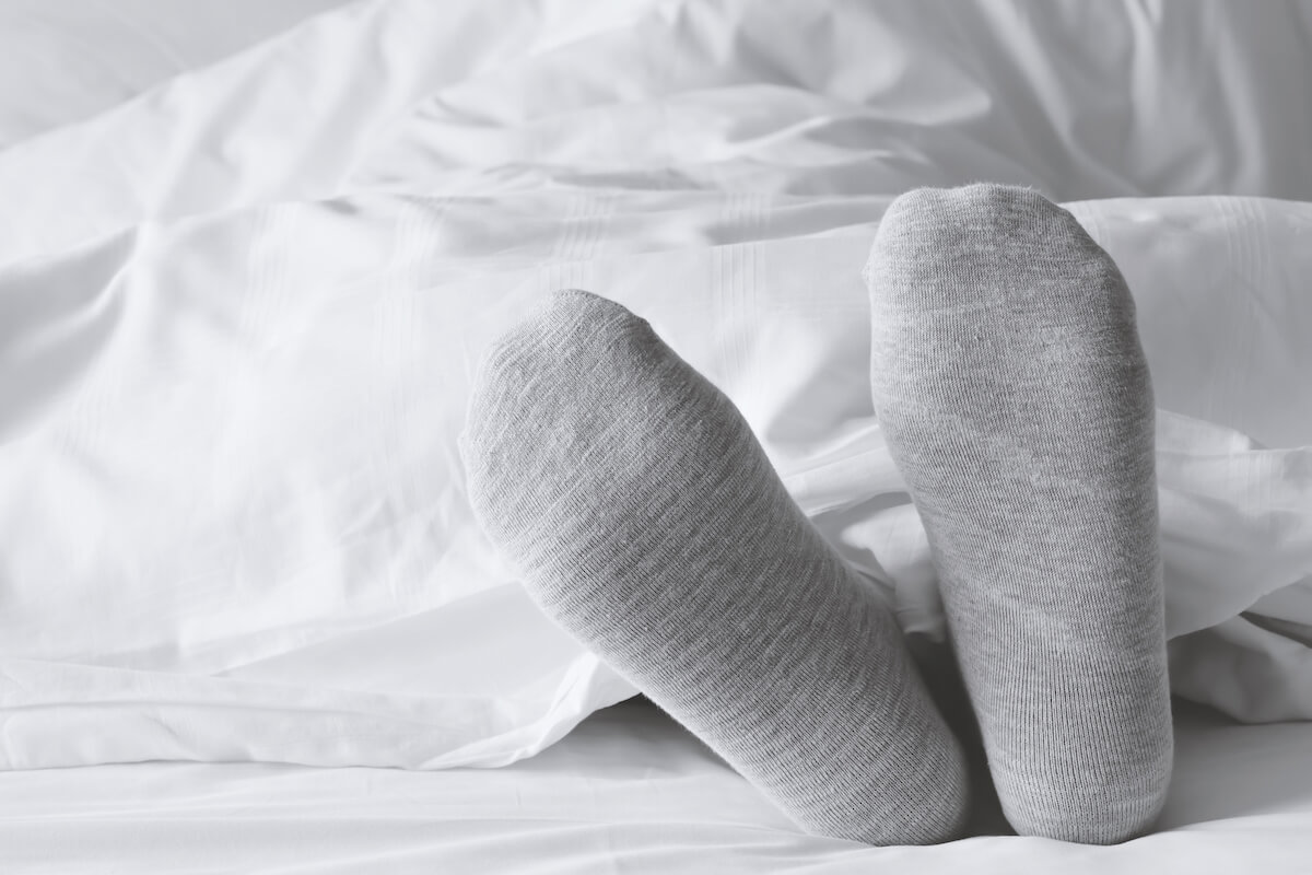 Person wearing socks under the sheets