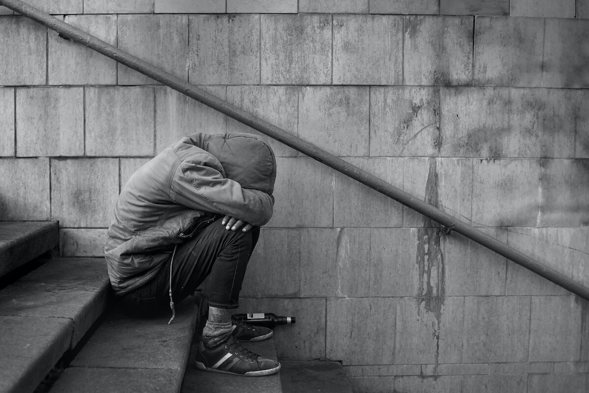 how long can you go without sleep: Man taking a nap in public while sitting on the stairs